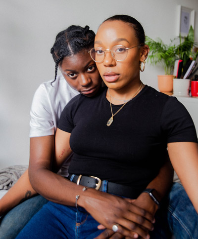 A Black LGBTQ+ couple holds each other in grief.